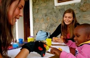 Voluntarias en actividades lúdicas en Tanzania Voluntarias y niña en actividad con títeres en Tanzania